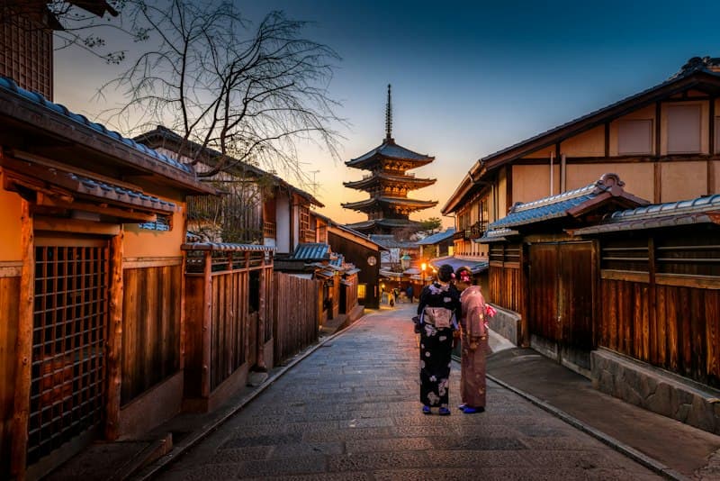 Traditional Japanese pagoda and garden framed by vibrant greenery in Kyoto