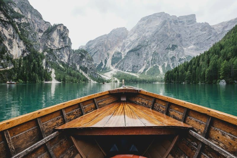 Wooden rowboats resting on serene alpine glacial lake